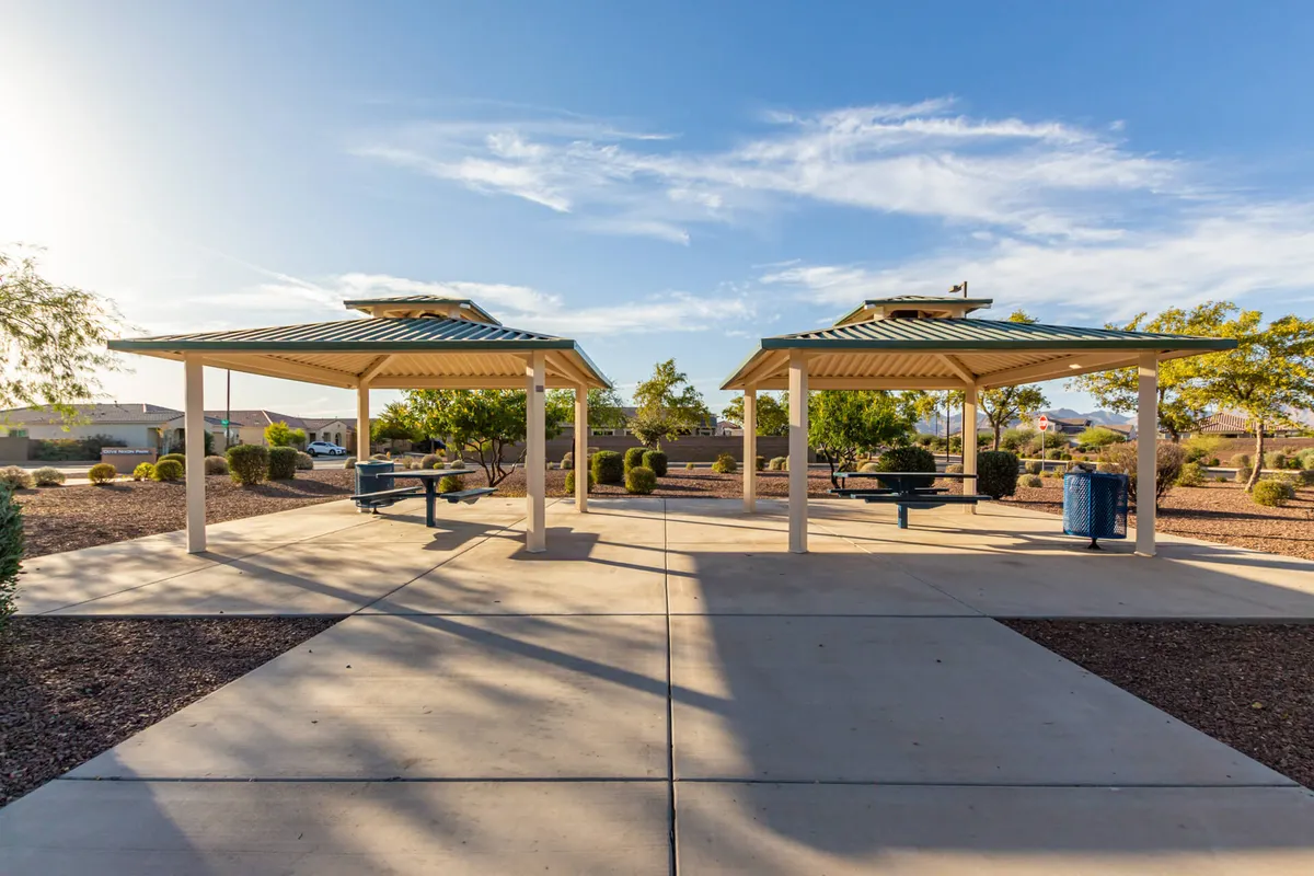 A landscaped community area with two gazebos, a meandering pathway, and lush greenery—inviting for walks, outdoor gatherings, and sunset picnics. The open space is ideal for exploration and spontaneous adventures.
